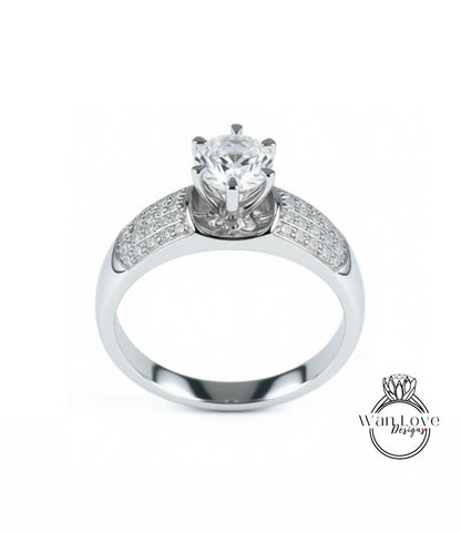 A silver engagement ring with a large central diamond surrounded by smaller diamonds on either side.