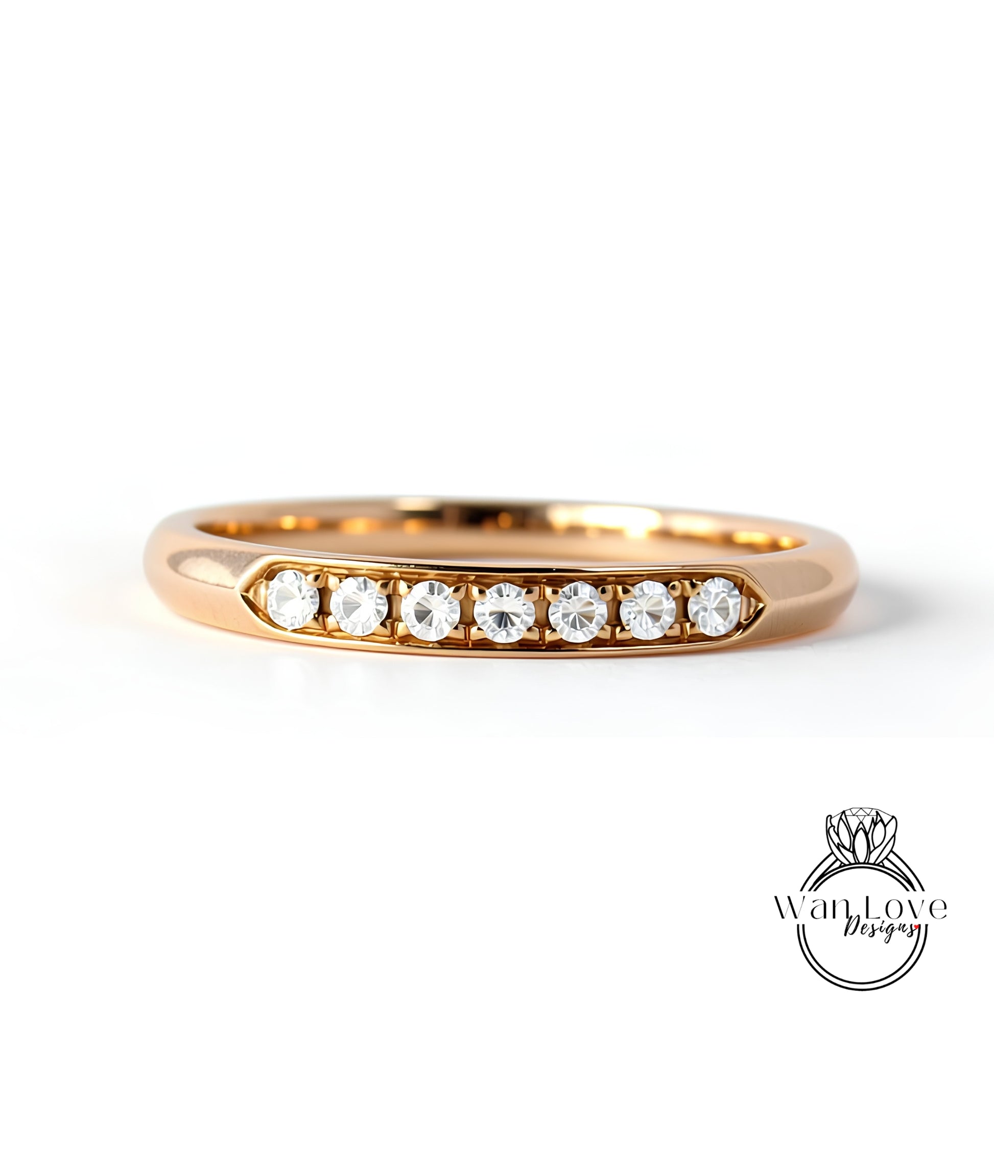 A gold ring with a row of clear gemstones set in the band.