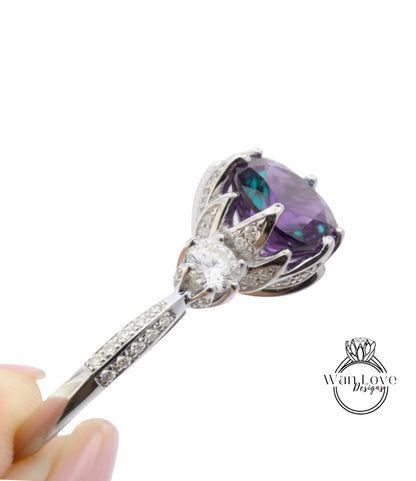 A close-up view of a silver ring with a large purple gemstone, possibly a sapphire, and a smaller clear gemstone.