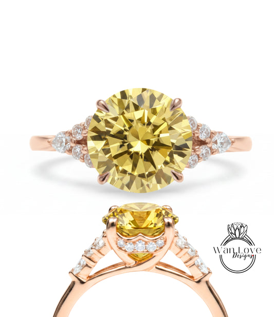 a beautiful yellow diamond engagement ring with a rose gold band and a row of small diamonds on either side of the large yellow diamond.