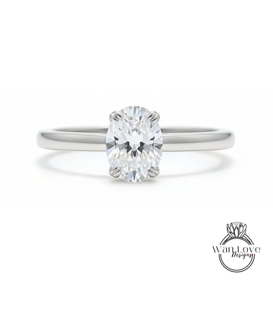A close-up view of a diamond engagement ring with a large oval-shaped diamond set in a silver band.