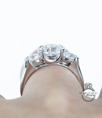 A close-up view of a person's hand wearing a silver ring with a large, clear gemstone set in the center.