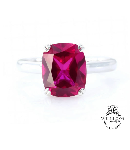 A ring with a large, deep red gemstone, likely a ruby, set in a silver band.