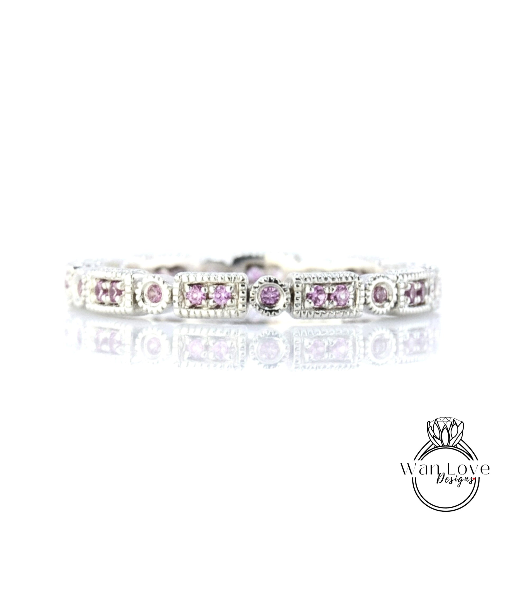 A silver bracelet with a row of rectangular gemstones, including pink gemstones, set in a decorative pattern.