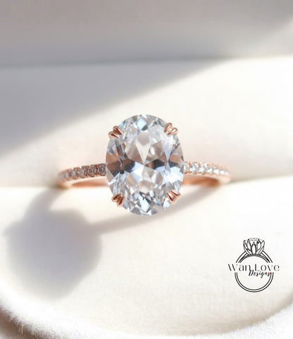 A close-up image of a diamond engagement ring with a large oval-shaped diamond set in a rose gold band.