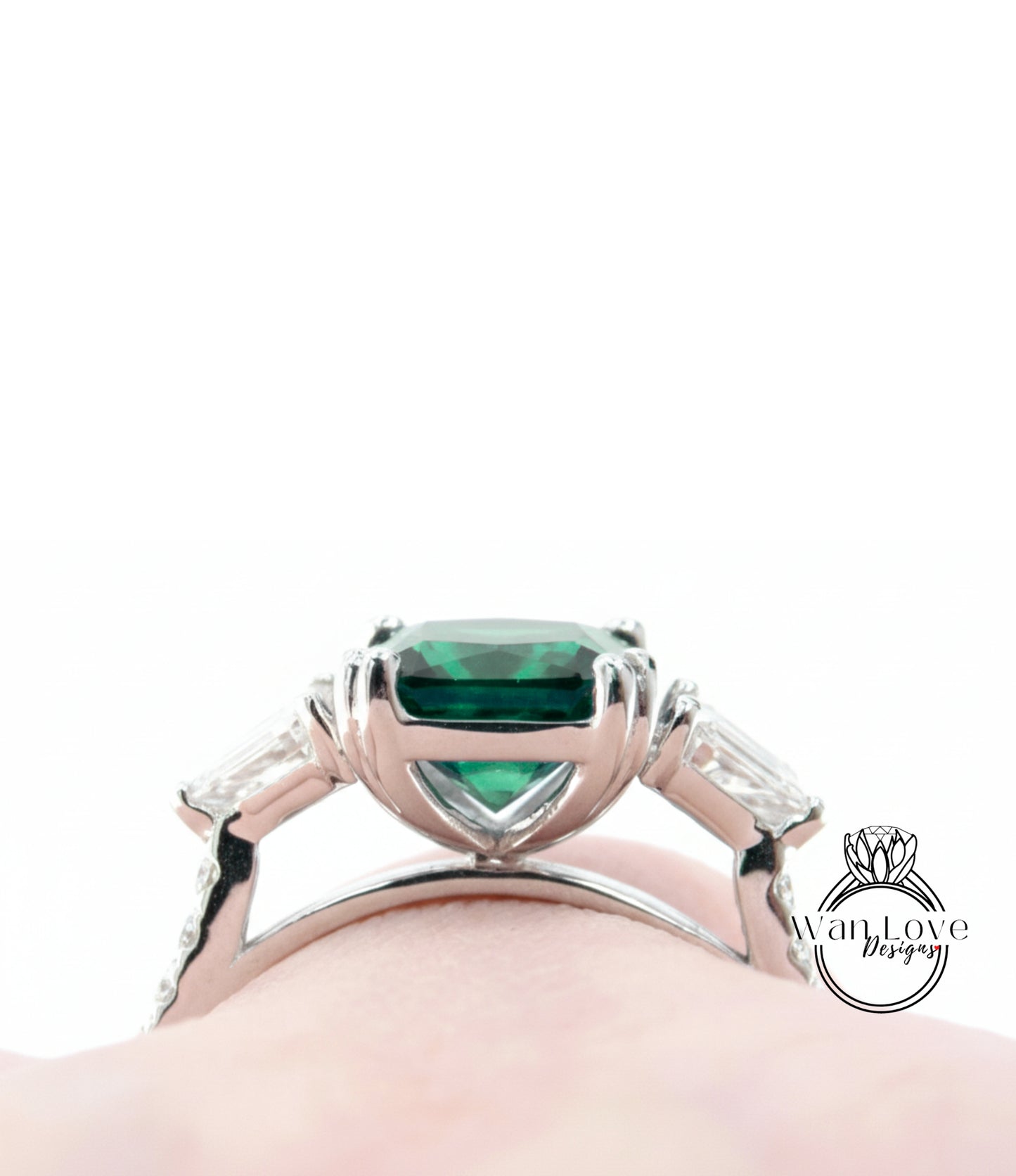 A close-up view of a silver ring with a large, green gemstone set in the center.