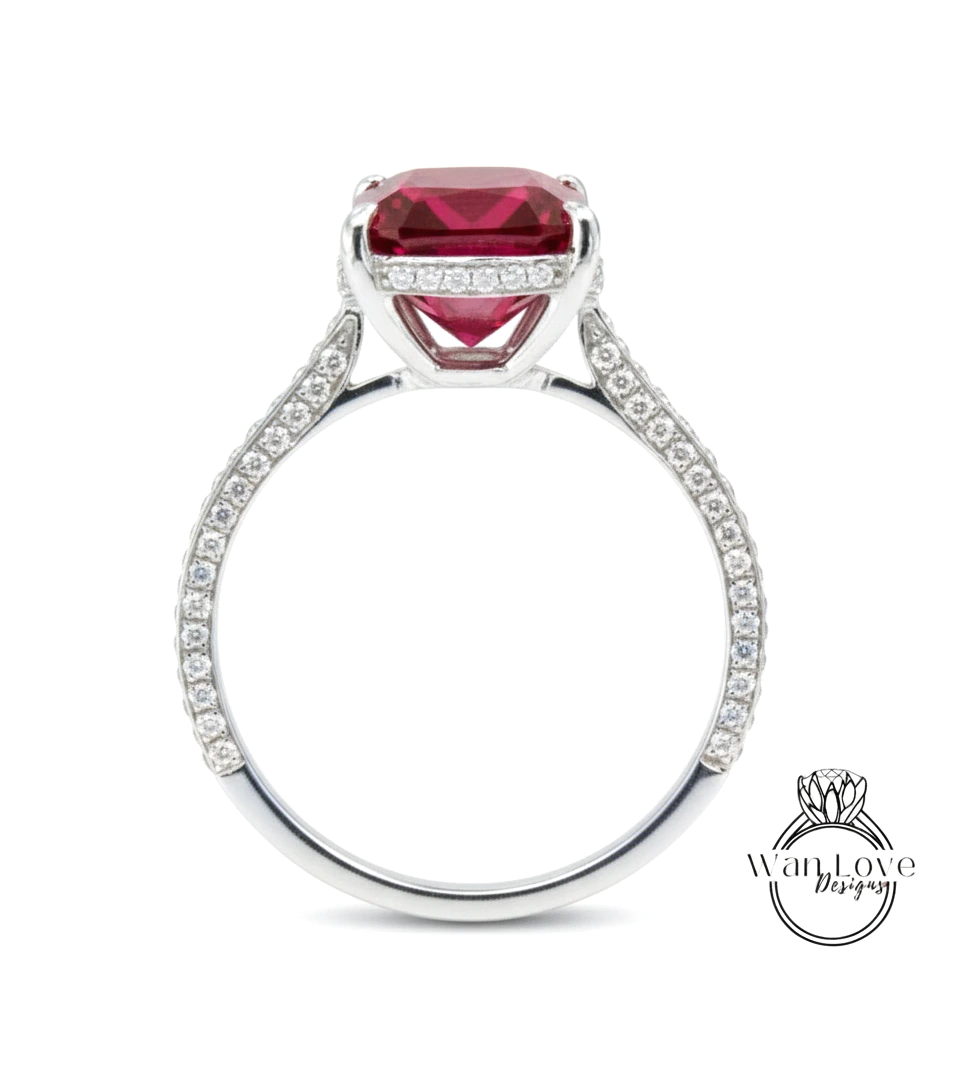 A silver ring with a large, red gemstone at the center, surrounded by smaller diamonds.