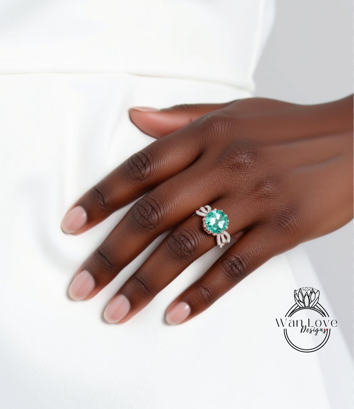 A close-up of a hand wearing a ring with a large green gemstone.