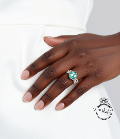 A close-up of a hand wearing a ring with a large green gemstone.