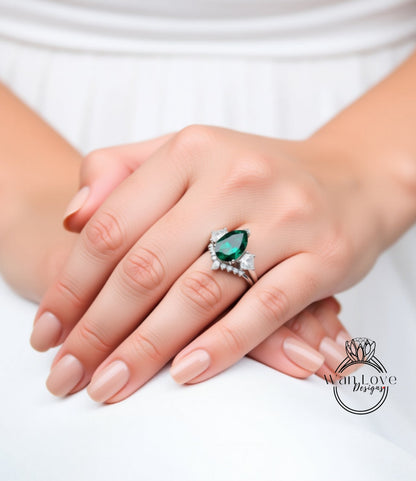 A close-up of a person's hand wearing a ring with a large green gemstone.
