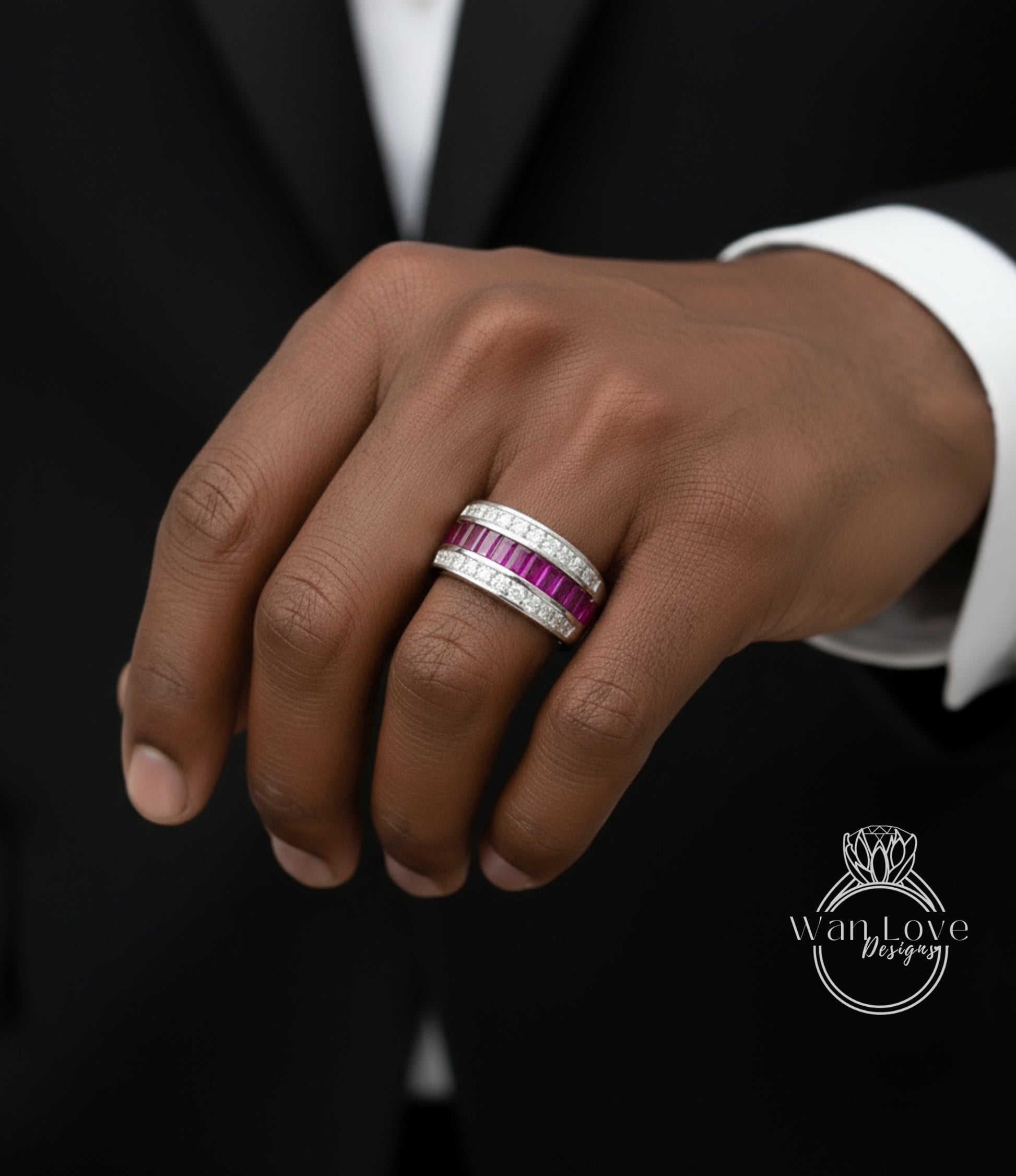 A close-up of a person's hand wearing a ring with a large band and a smaller band with pink gemstones.