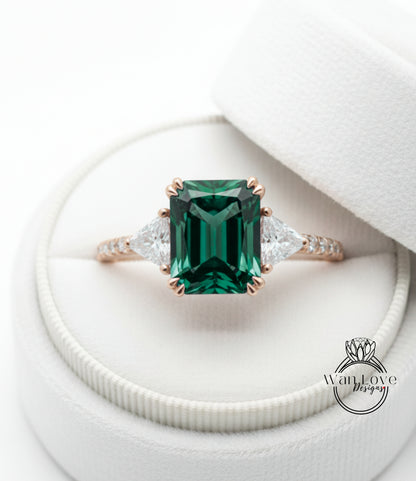 A beautiful engagement ring with a large, green gemstone set in a gold band, placed in a white jewelry box.