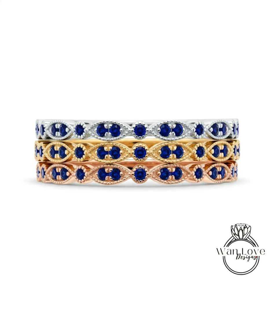 A stack of three rings with blue gemstones set in gold and silver tones.