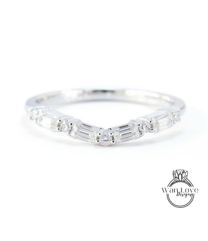 A silver ring with a unique design featuring a central diamond surrounded by smaller diamonds arranged in a curved pattern.