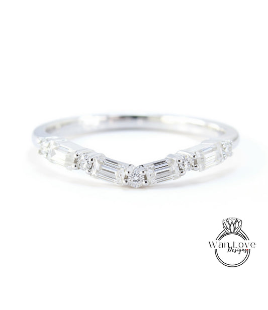 A silver ring with a unique design featuring a central diamond surrounded by smaller diamonds arranged in a curved pattern.