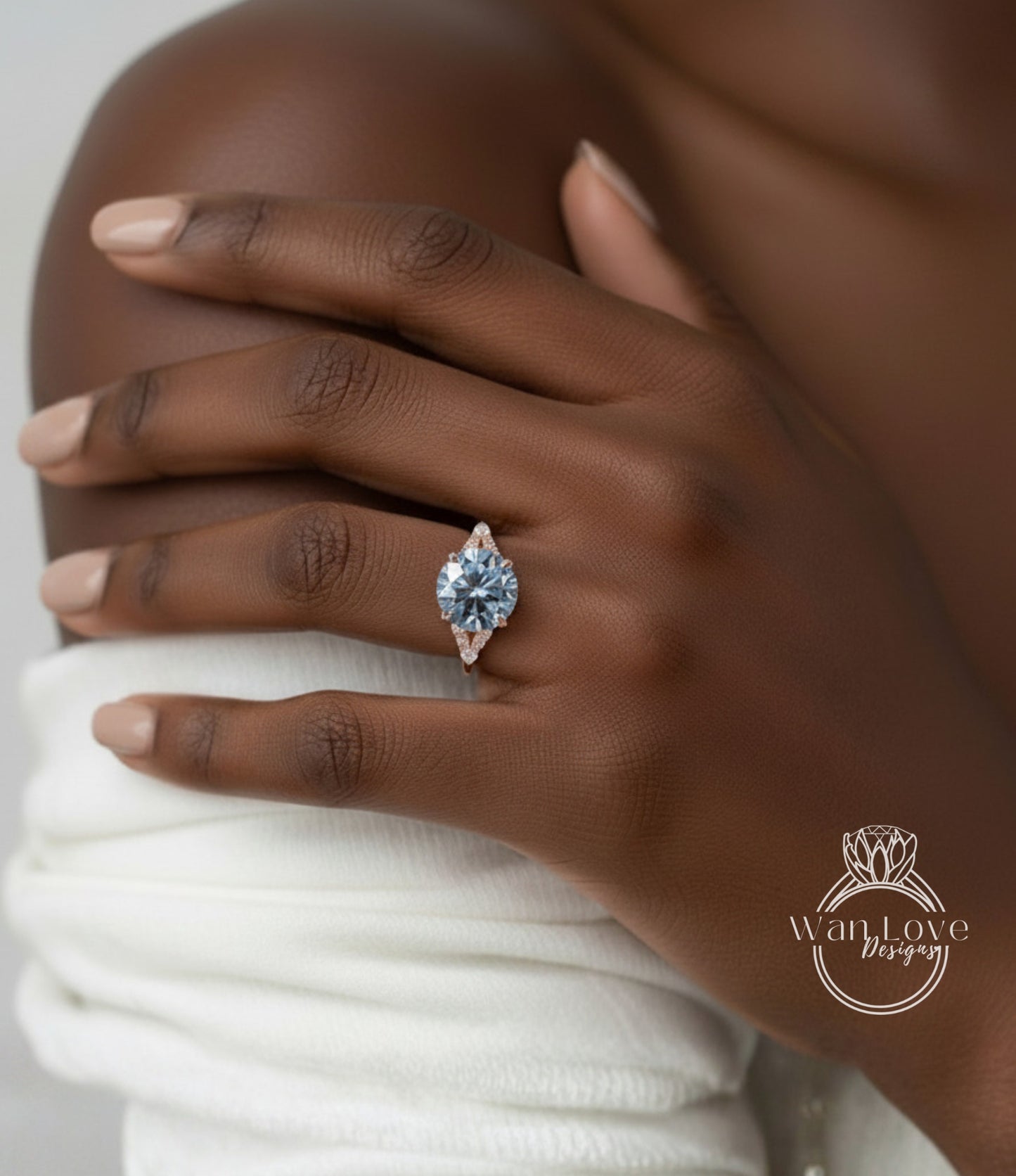 A close-up of a person's hand wearing a diamond engagement ring on the ring finger.