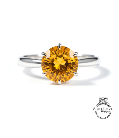 A close-up image of a silver ring with a large, bright yellow gemstone, which appears to be a diamond.