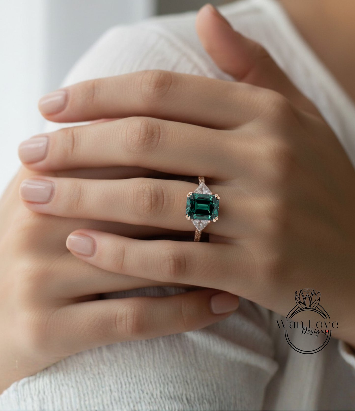 A close-up of a person's hand wearing a large, green gemstone ring with a gold band.