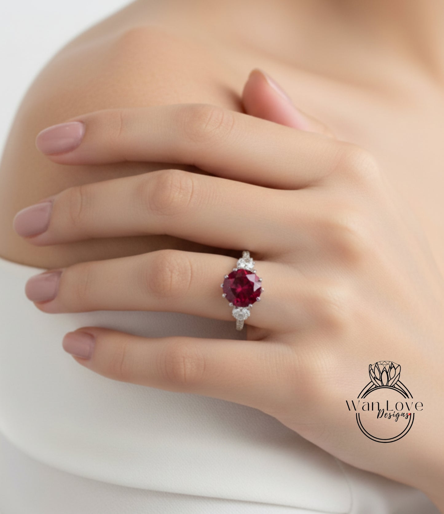 A close-up of a person's hand wearing a ring with a large, vibrant red gemstone.