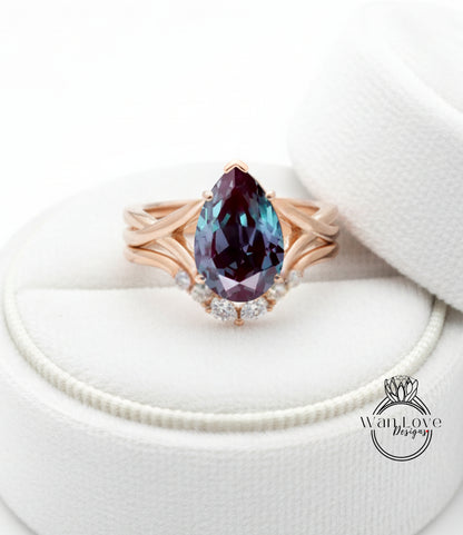 A gold ring with a large purple gemstone, possibly a pear-shaped gemstone, set in a ring band with smaller diamonds.