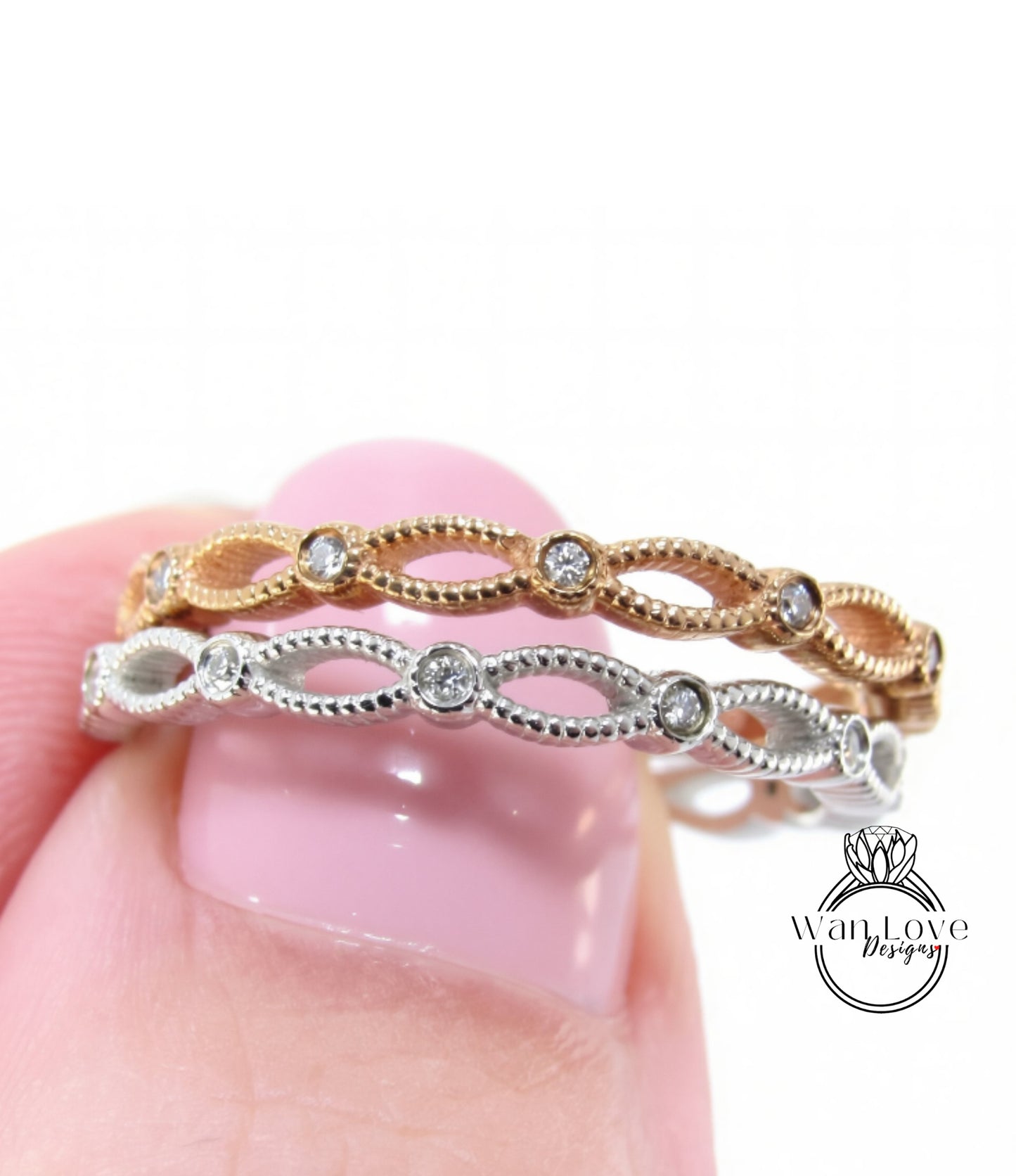 A close-up of a person's hand holding a ring with a decorative band of diamonds.