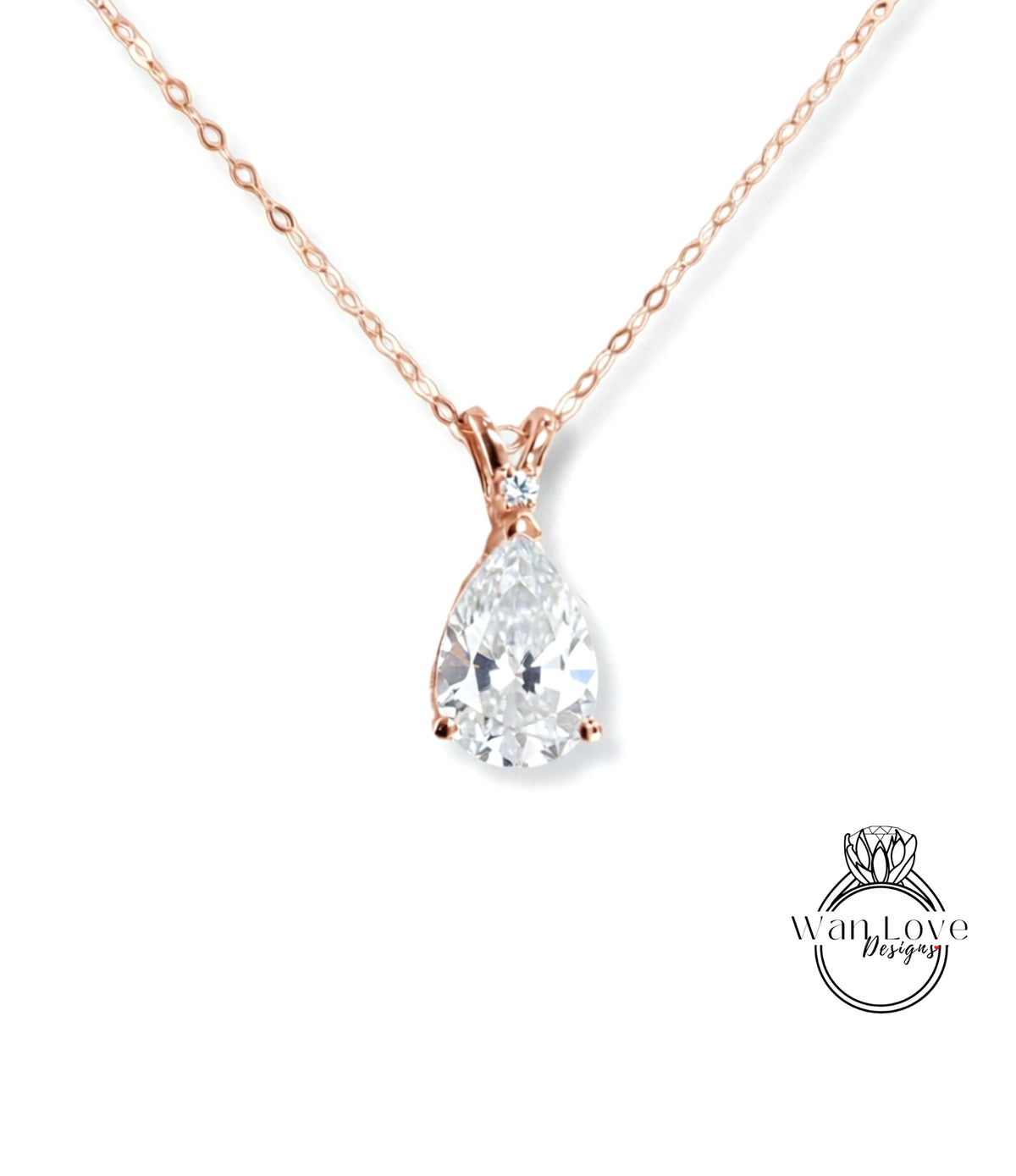 A close-up view of a delicate rose gold necklace with a large, clear pear-shaped diamond pendant.