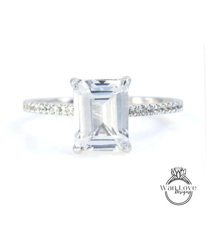 A diamond engagement ring with a large, clear gemstone set in a silver band.