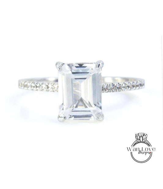 A diamond engagement ring with a large, clear gemstone set in a silver band.