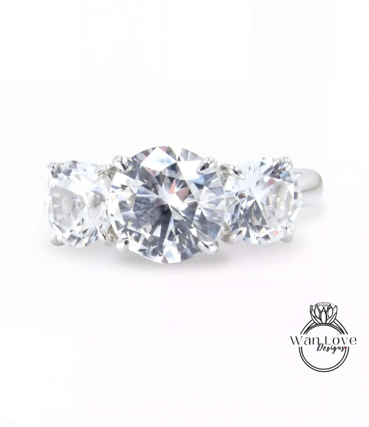 A close-up image of a diamond ring with three large, clear diamonds set in a silver band.