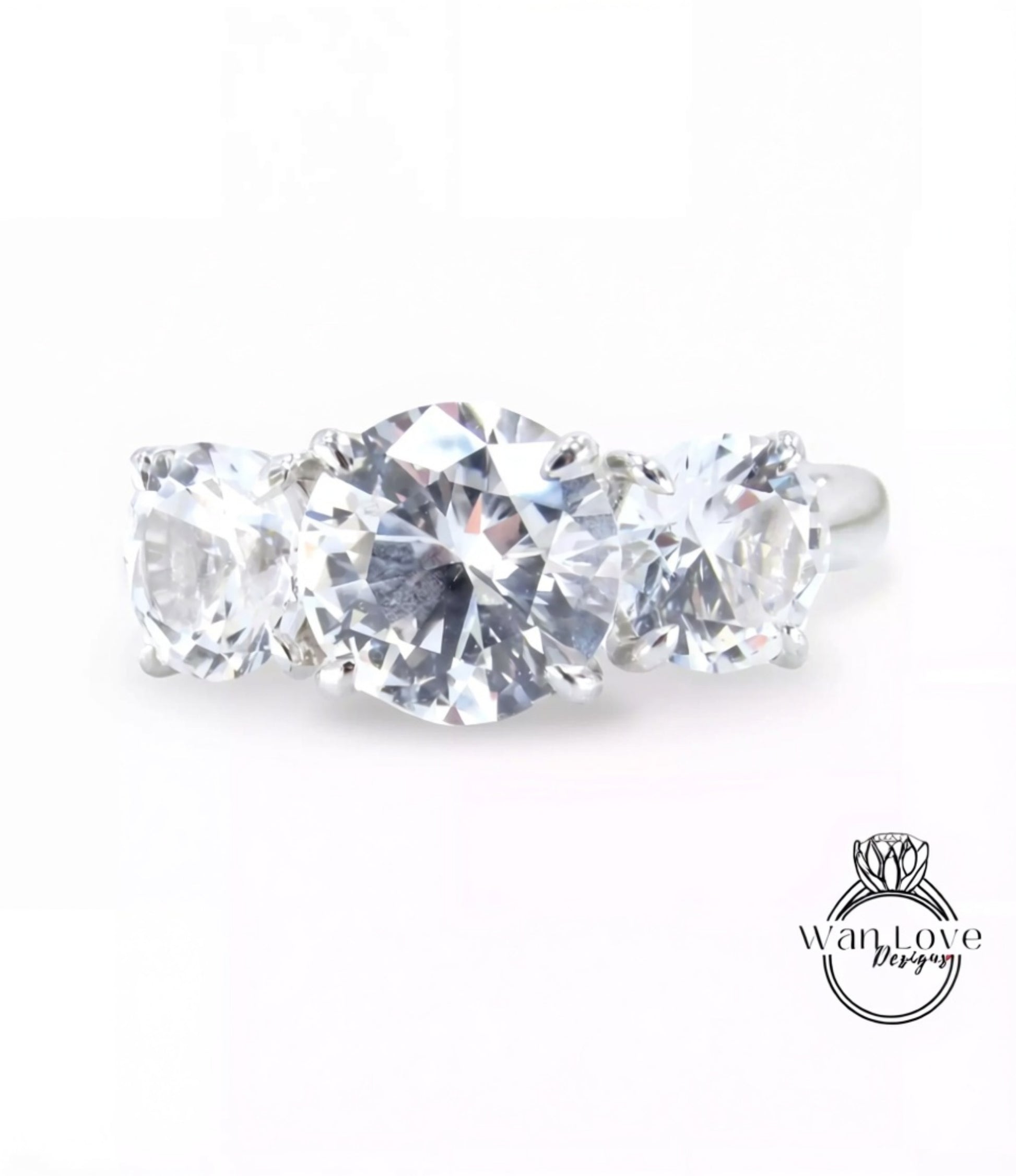 A close-up image of a diamond ring with three large, clear diamonds set in a silver band.