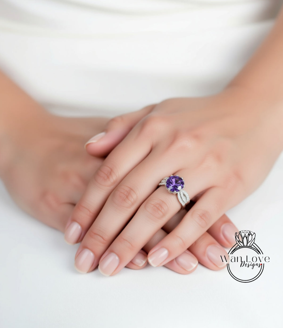 A close-up image of a person's hands wearing a ring with a purple gemstone.