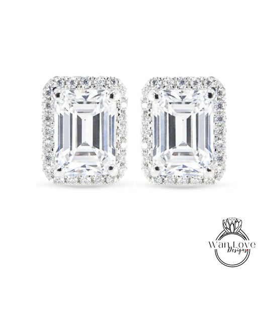 A pair of elegant earrings with large, clear gemstones set in a halo of smaller diamonds.