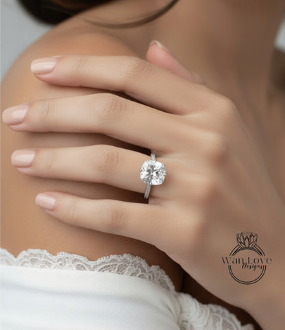 A close-up of a person's hand wearing a large diamond engagement ring.