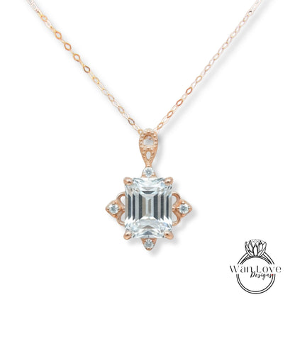 A necklace with a large, clear gemstone pendant, which appears to be a diamond. The pendant is set in a rose gold-colored metal and has an intricate design around it.