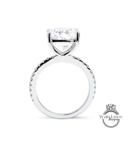 A large, clear diamond engagement ring with a large central diamond and a smaller diamond band around the base.