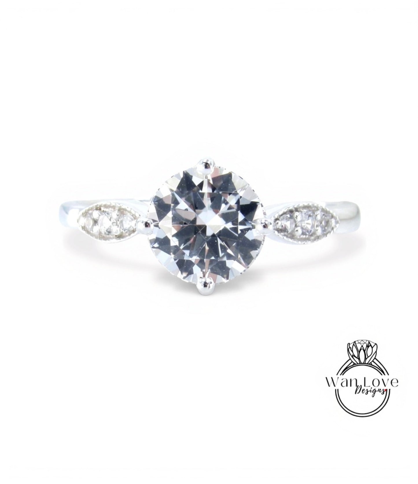 A close-up view of a diamond engagement ring with a large central diamond surrounded by smaller diamonds on either side.