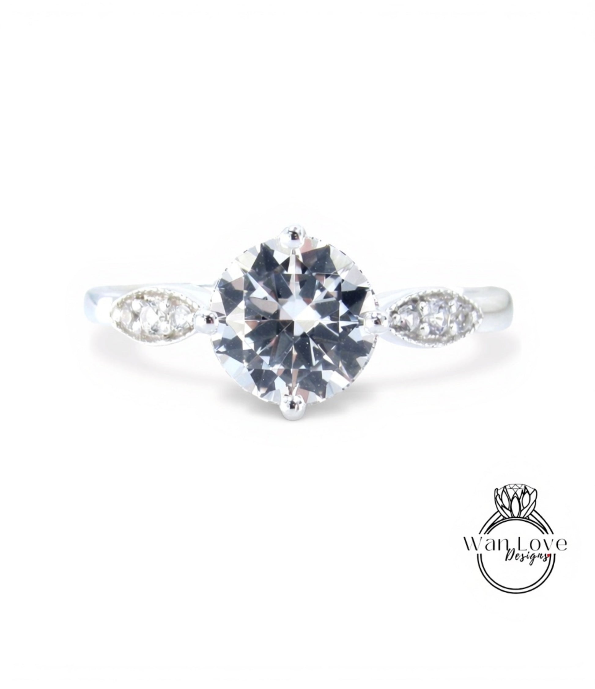 A close-up view of a diamond engagement ring with a large central diamond surrounded by smaller diamonds on either side.