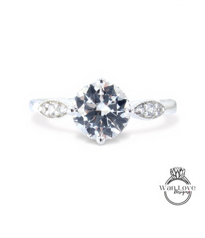 A close-up view of a diamond engagement ring with a large central diamond surrounded by smaller diamonds on either side.