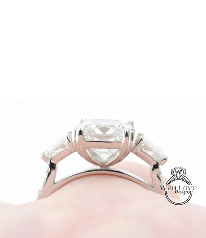 A close-up view of a large, elegant diamond engagement ring with a large central diamond surrounded by smaller diamonds on either side.