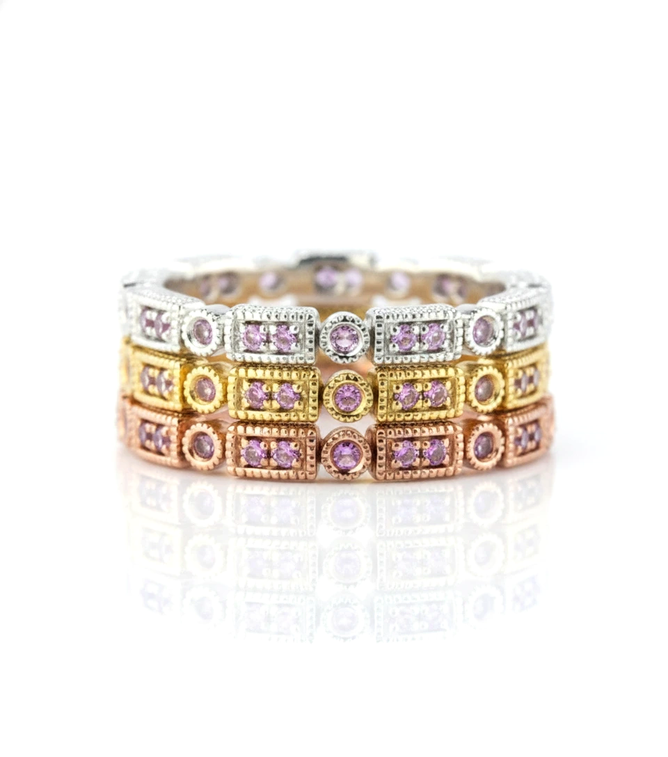 A ring with multiple layers of rings, each ring featuring a small purple gemstone. The rings are arranged in a circular pattern, creating a visually appealing and intricate design.