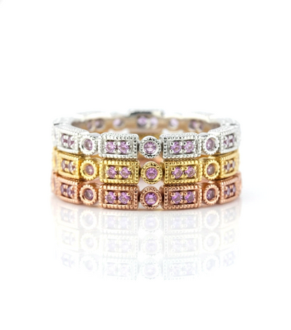A ring with multiple layers of rings, each ring featuring a small purple gemstone. The rings are arranged in a circular pattern, creating a visually appealing and intricate design.