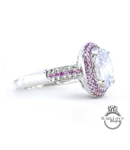 A silver ring with a large, clear gemstone at the center, surrounded by a border of smaller, purple gemstones.