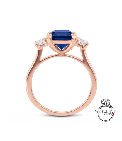 A rose gold ring with a large blue gemstone set in the center, surrounded by smaller diamonds.