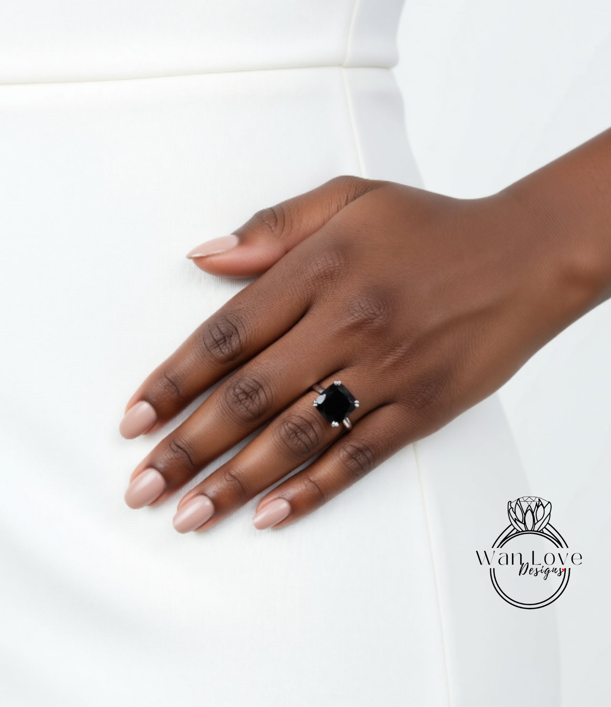 A close-up of a hand wearing a ring with a large black gemstone.