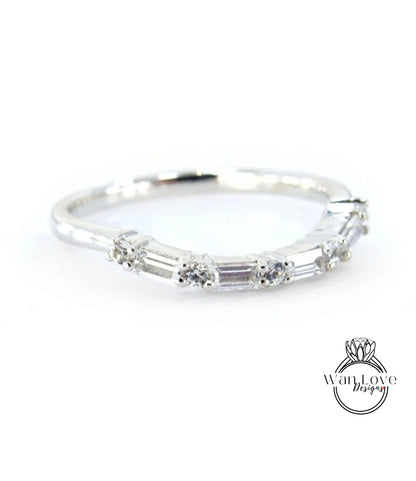A silver ring with a row of small diamonds set in it.