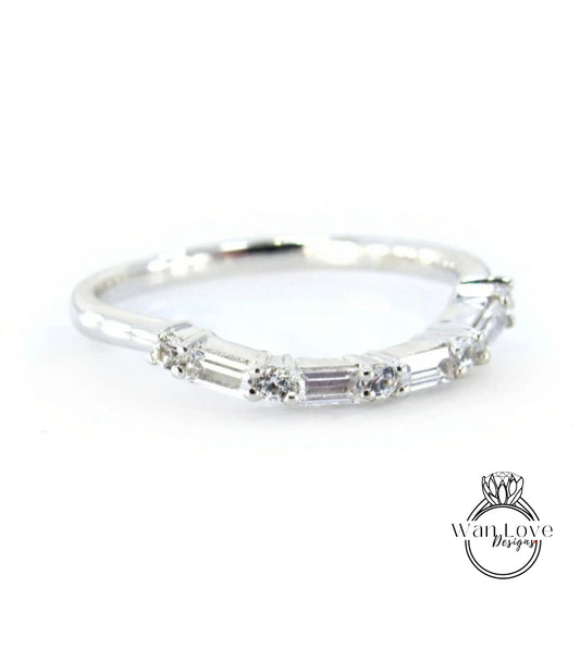 A silver ring with a row of small diamonds set in it.