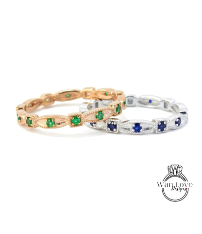 two rings with green and blue gemstones set in a gold and silver band.