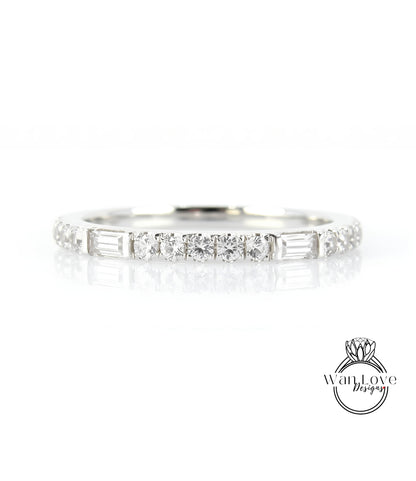 A silver ring with a row of small diamonds set in it, reflecting light and creating a shiny appearance.