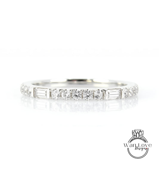 A silver ring with a row of small diamonds set in it, reflecting light and creating a shiny appearance.