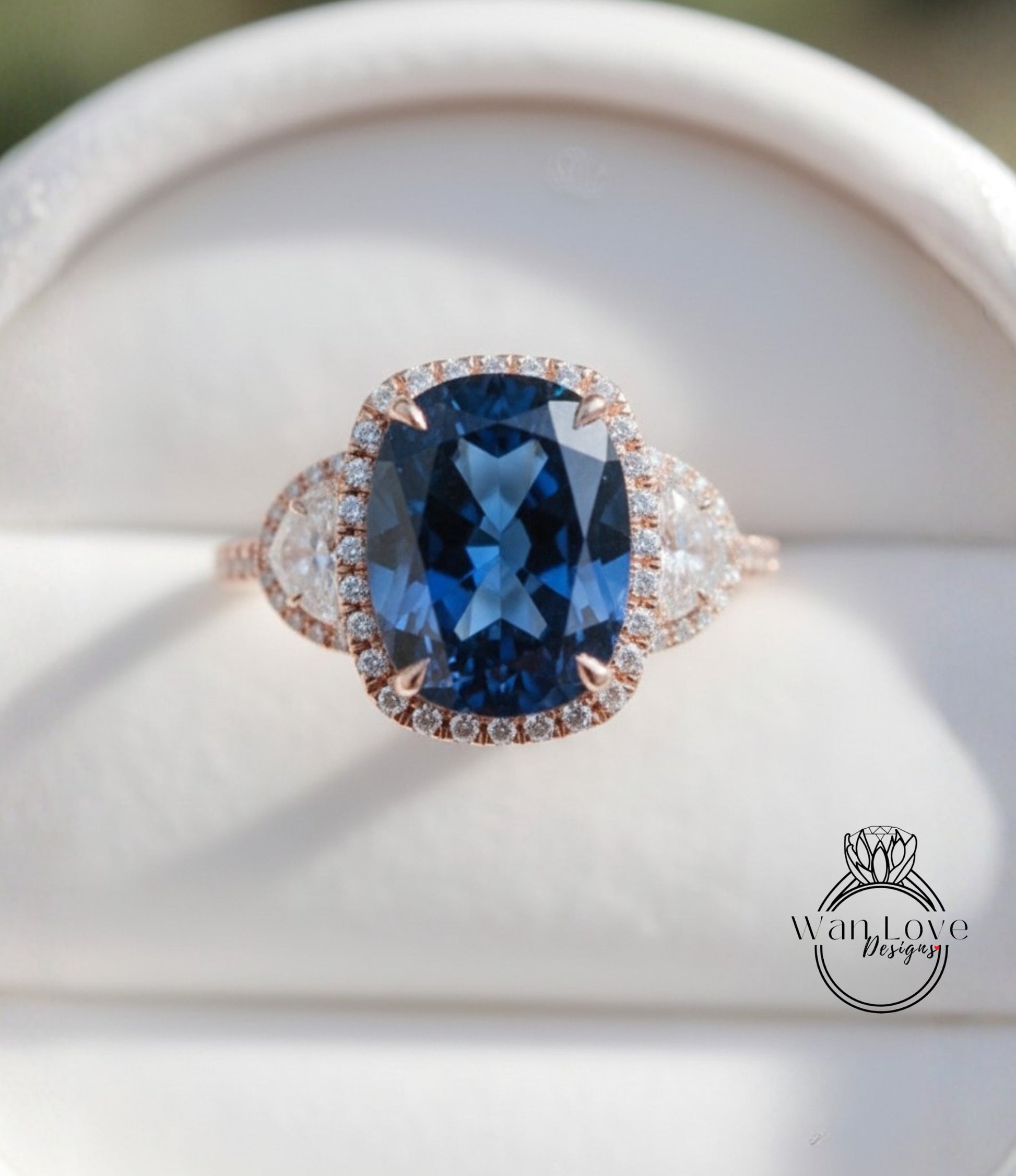 A close-up image of a large blue gemstone ring with a halo of smaller diamonds around the center stone.